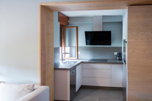 a kitchen with white cabinets and a sink in a room at APARTAMENTOS BARCELLA TAPIA in Tapia de Casariego
