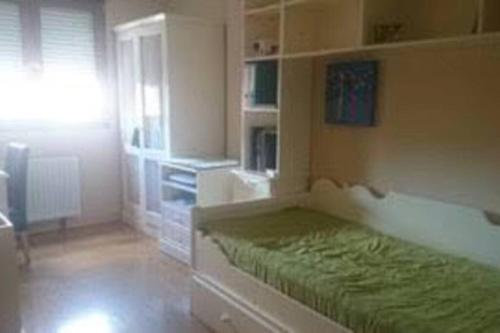 een witte kamer met een bed en een raam bij Piso en Los corrales de buelna (Cantabría) in Los Corrales de Buelna