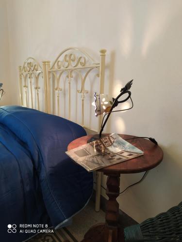 a table with a lamp on it next to a bed at Agli Antichi Quartieri Apartments in Alcamo