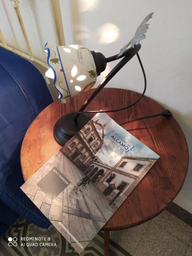 a table with a book and a lamp on it at Agli Antichi Quartieri Apartments in Alcamo