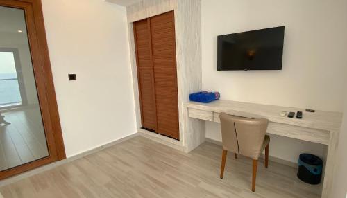 a room with a desk with a television and a chair at Kaani Palm Beach in Maafushi