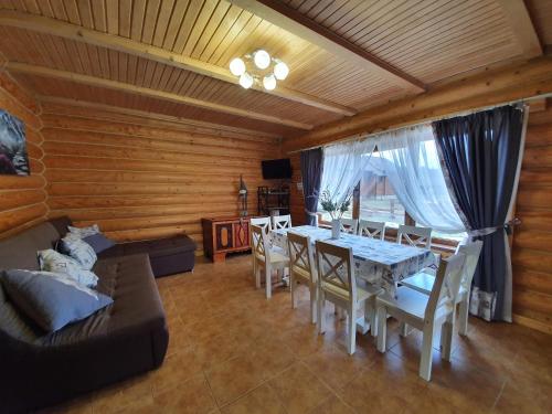 a living room with a table and chairs and a couch at Khytir Falchi in Mykulychyn