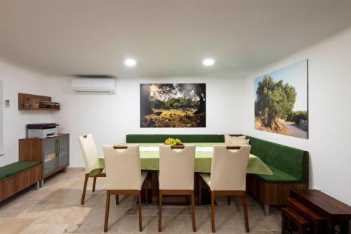 a dining room with a green table and chairs at Moon Stone Residence Pag in Pag
