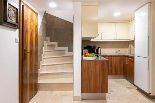 a kitchen with a staircase with a bowl of fruit on a counter at Moon Stone Residence Pag in Pag