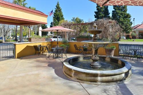 a fountain in a patio with tables and chairs at Holiday Inn Rancho Cordova - Northeast Sacramento by IHG in Rancho Cordova