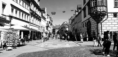 a black and white photo of a city street with people at Fränkische Landherberge, Hotel Garni in Seßlach
