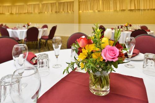 a table with a vase of flowers on a table at Holiday Inn Rancho Cordova - Northeast Sacramento by IHG in Rancho Cordova