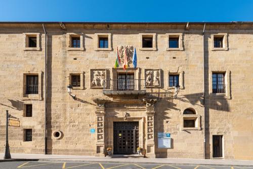 a large brick building with a door and a balcony at Eurostars Los Agustinos in Haro