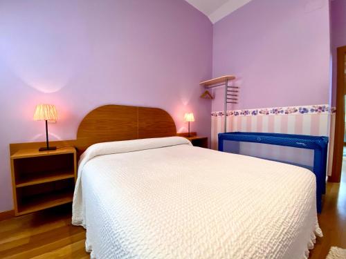 1 dormitorio con cama blanca y paredes moradas en Apartamento Turistico Plaza Mayor en Burgos