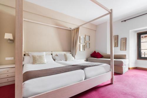 a bedroom with two beds and a canopy bed at Eurostars Los Agustinos in Haro