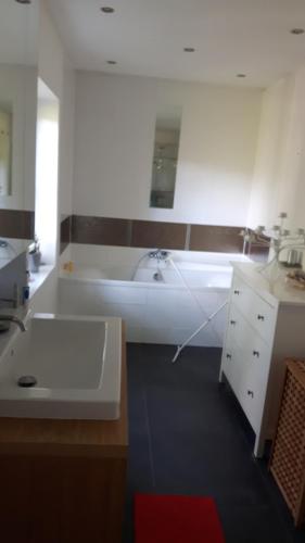 un bagno bianco con vasca e lavandino di ruhiges Zimmer in Pankow a Berlino