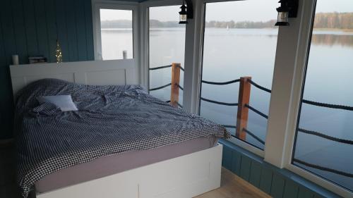 a bed in a room with a view of the water at Dom na wodzie nad Jeziorem Krzywe in Piecki