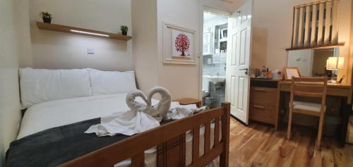 a bedroom with a bed with towels on it at Chatsworth Guest House in London