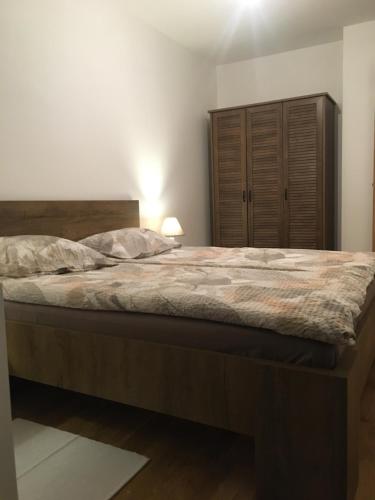 ein Schlafzimmer mit einem großen Bett und einem Holzschrank in der Unterkunft Fantastic Apartment De LUX in Sarajevo