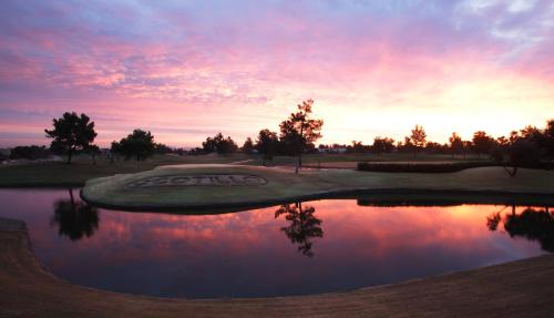a golf course with a pond at sunset at Holiday Inn Phoenix/Chandler by IHG in Chandler