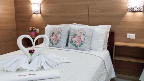 a bed with two swans dressed in white at Planet Dunas Residence in Aquiraz