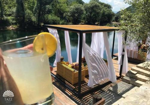 a drink with a lemon slice in front of a gazebo at Hotel Tazz - River Front Oasis Collection in Bihać