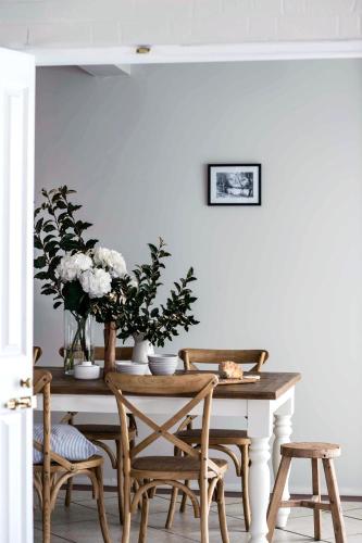 a dining room table with chairs and flowers on it at Evanslea Luxury Boutique Accommodation in Mudgee