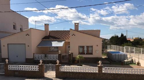 uma casa branca com uma cerca à frente. em Casa Felix em Sant Jaume d'Enveja