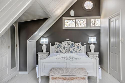 a bedroom with a white bed and white walls at Evanslea Luxury Boutique Accommodation in Mudgee