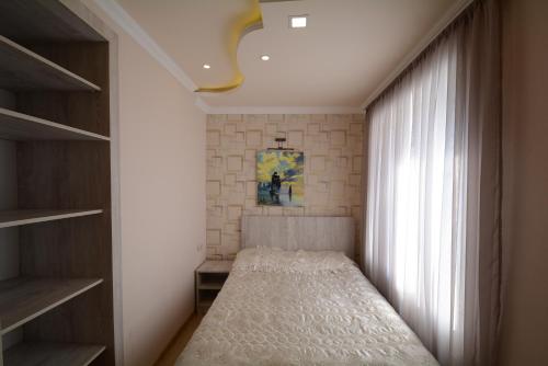 a small bedroom with a bed and a window at Apartment in Sevan