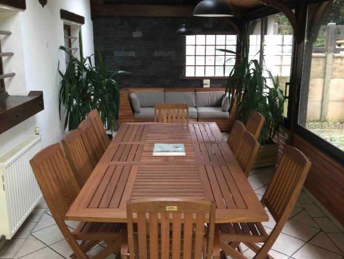 a wooden table and chairs on a patio at Appart, maison 100m2,, Parc des expositions et Aéro CDG 10mn, Parc Astérix 25mn in Villepinte