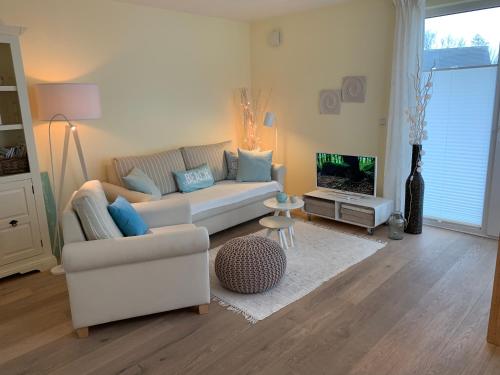 a living room with a couch and a tv at Beach Home in Sankt Peter-Ording
