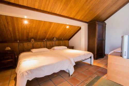 a bedroom with a large bed with a wooden ceiling at Quinta da Mesquinhata in Lamego