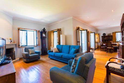a living room with a blue couch and chairs at Quinta da Mesquinhata in Lamego