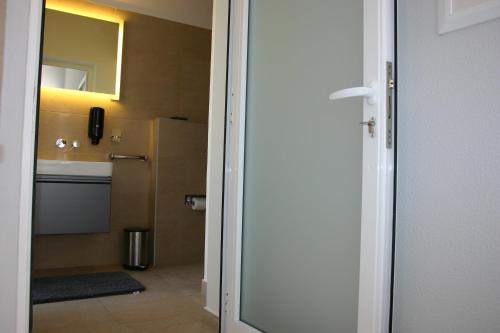 a bathroom with a refrigerator and a sink at Casinha Vista Mar in Porto Santo