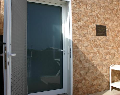 a sliding glass door with a stone wall at Casinha Vista Mar in Porto Santo
