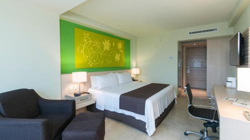 コアツァコアルコスにあるHoliday Inn Coatzacoalcos, an IHG Hotelのベッド、デスク、椅子が備わるホテルルームです。