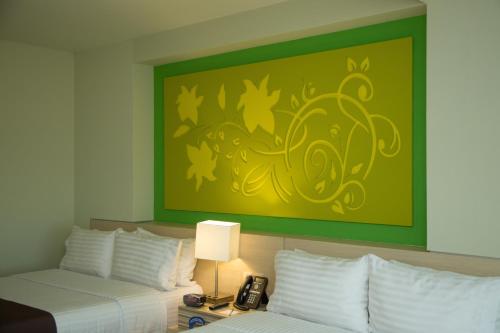 a hotel room with two beds and a painting on the wall at Holiday Inn Coatzacoalcos by IHG in Coatzacoalcos