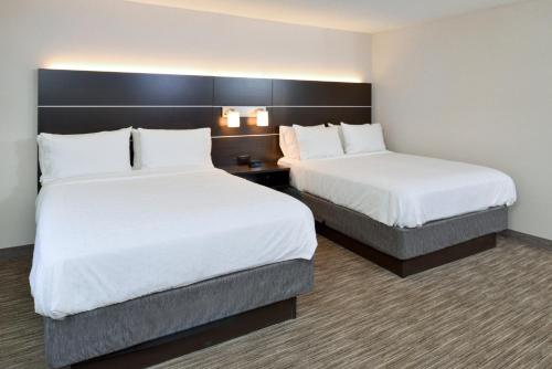 a hotel room with two beds with white sheets at Holiday Inn Express Wixom by IHG in Wixom