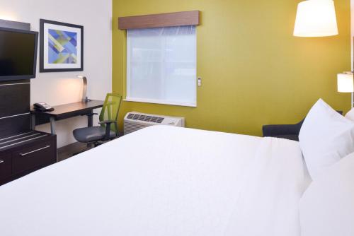 a hotel room with a large bed and a desk at Holiday Inn Express Wixom by IHG in Wixom