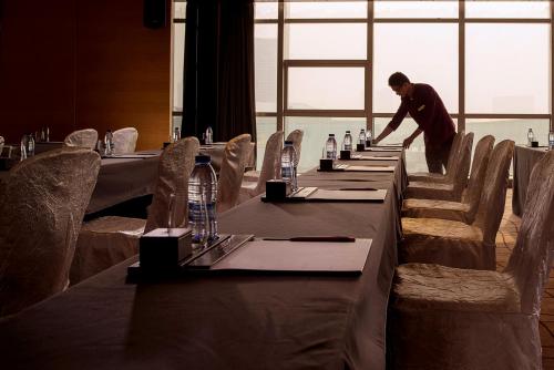 a man standing at a long table in a restaurant at Expo Center Hotel - Free Shuttle Bus & Late Check-out in Yiwu