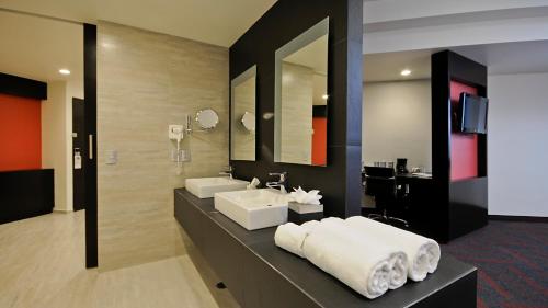 a bathroom with two sinks and a mirror at Holiday Inn Mexico Dali Airport by IHG in Mexico City