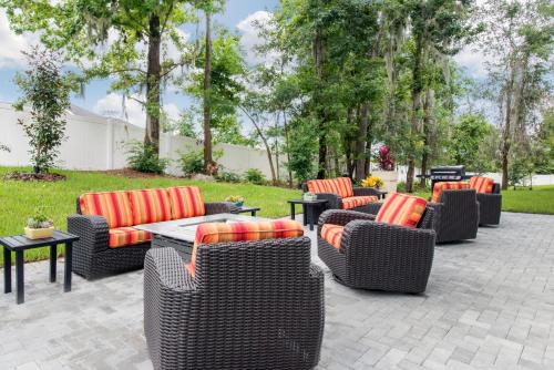 a group of wicker chairs and tables on a patio at Holiday Inn Express & Suites Alachua - Gainesville Area by IHG in Alachua