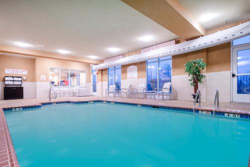 a pool at a hotel with tables and chairs at Holiday Inn Manassas - Battlefield, an IHG Hotel in Manassas
