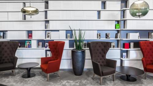 a waiting room with two chairs and a vase with a plant at Holiday Inn Munich - Westpark by IHG in Munich