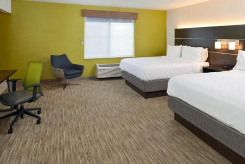 a hotel room with two beds and a desk and chair at Holiday Inn Express Wixom by IHG in Wixom