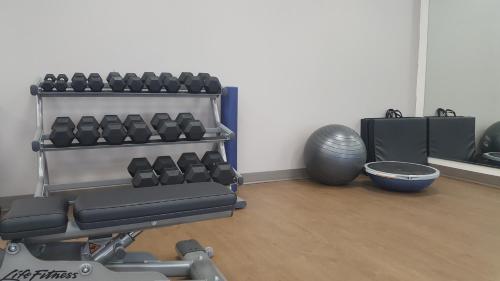 a room with a gym with a bench and weights at Holiday Inn Express & Suites West Memphis by IHG in West Memphis