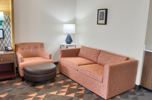 a living room with a couch and a chair at Holiday Inn Mobile West I-10 by IHG in Tillmans Corner