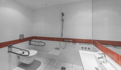 a bathroom with a toilet and a shower and a sink at Holiday Inn Munich - Leuchtenbergring by IHG in Munich
