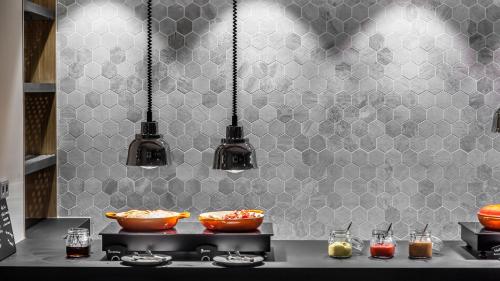 a kitchen with two bowls on a stove with lights at Holiday Inn Munich - Leuchtenbergring by IHG in Munich