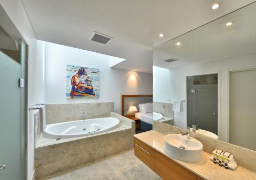 uma casa de banho com uma banheira e um lavatório em Sea Side Villa 10.1 em Mandurah