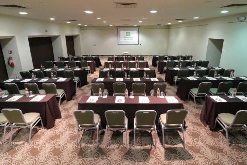 a room with rows of tables and chairs at Holiday Inn Monterrey Norte by IHG in Monterrey