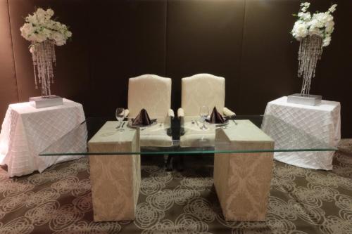 a glass table with two tables with wine glasses at Holiday Inn Monterrey Norte by IHG in Monterrey