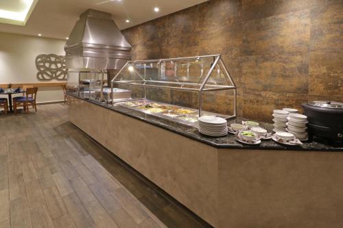 a restaurant with a counter with plates of food at Holiday Inn Monterrey Norte by IHG in Monterrey