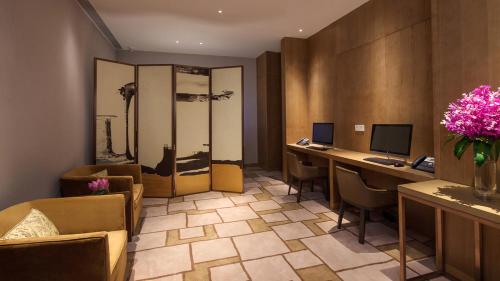 an office with two desks and two computers in a room at Holiday Inn Nanjing Qinhuai South by IHG in Jiangning
